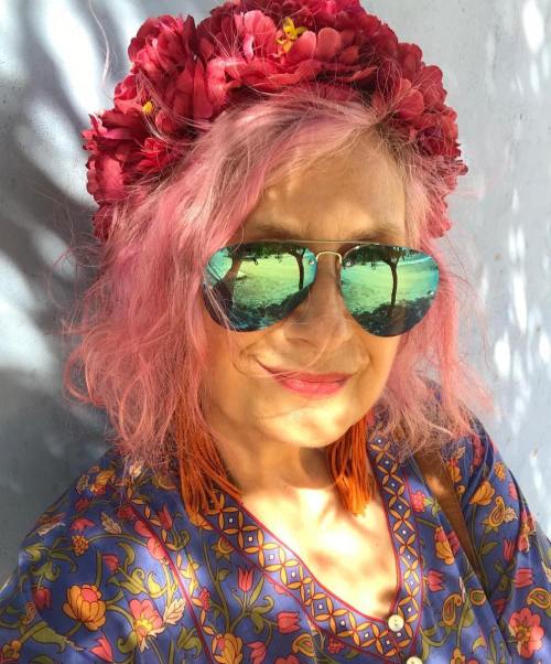 Mujer madura con melena corta rosa y corona de flores