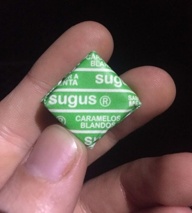Mano sosteniendo un dulce sugus de limón
