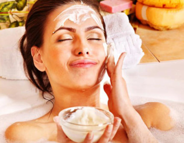 Chica aplicando mascarilla de avena con yogur sobre el rostro