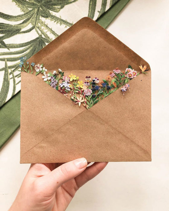 Miniramo de flores de papel de la artista Tania Lissova dentro de un sobre de cartón marrón