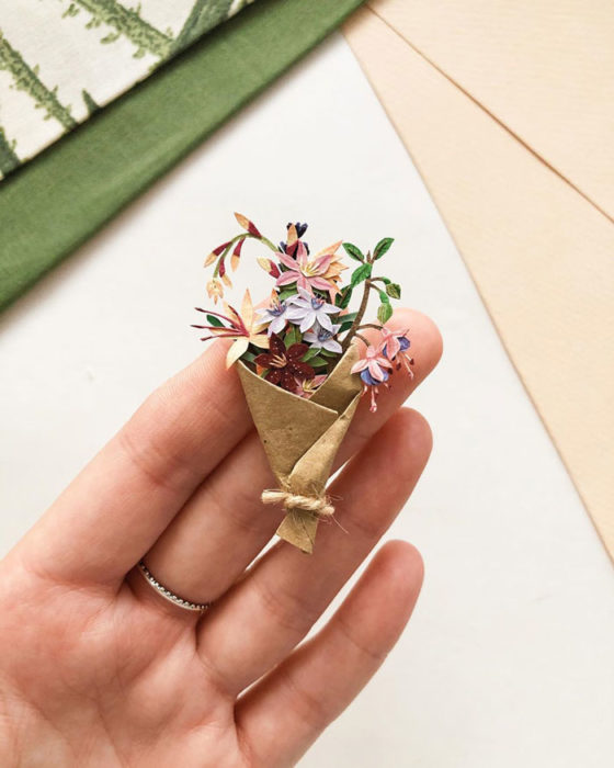 Miniramo de flores de papel de la artista Tania Lissova con tulipanes morados y azucenas envueltos en cartón marrón
