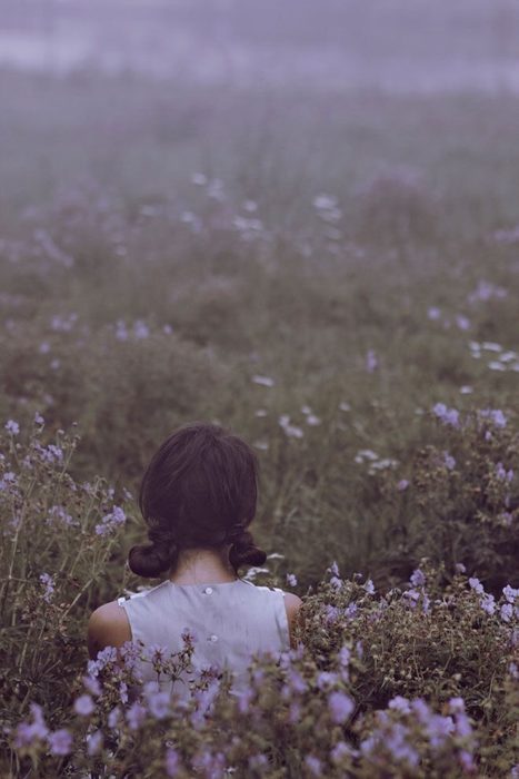 Chica con cabello corto de espaldas mira un campo de lavanda