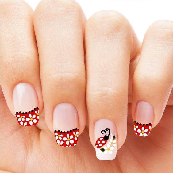 Manicura con franjas rojas en las puntas y una catarina
