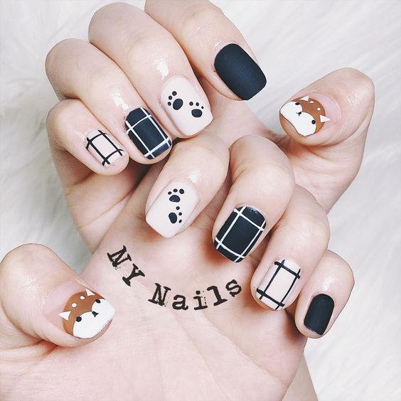 Manicura en tonos neutros con decoración de perritos en color café
