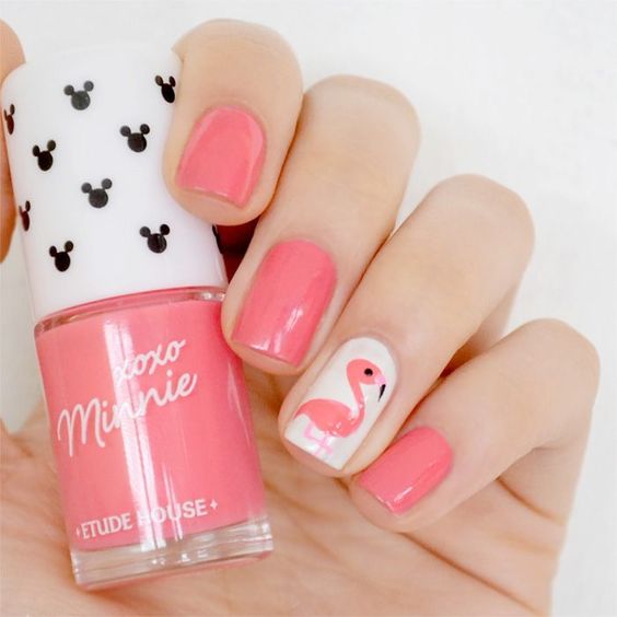 Manicura en tonos rosa con el diseño de un flamingo