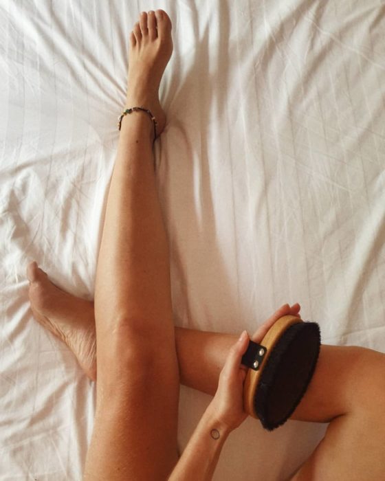 Chica cepillando sus piernas
