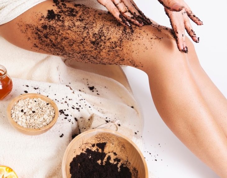Chica aplicando mascarilla de café y avena en las piernas