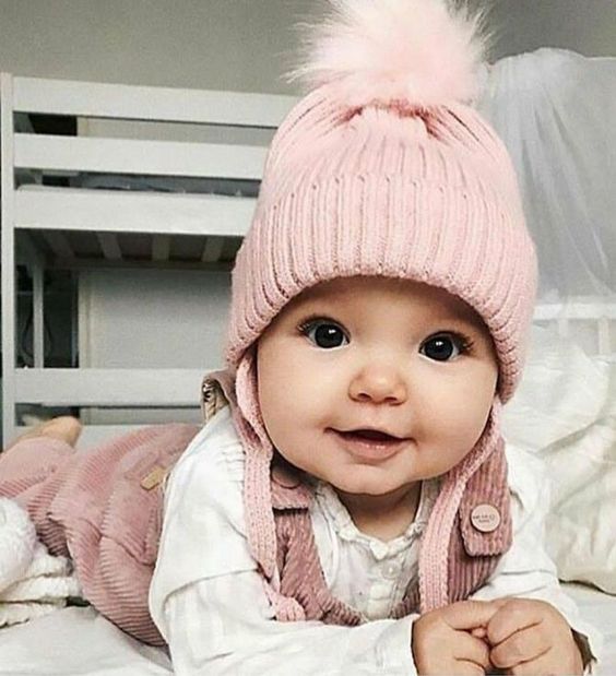 Bebé acostada boca abajo con gorro rosa