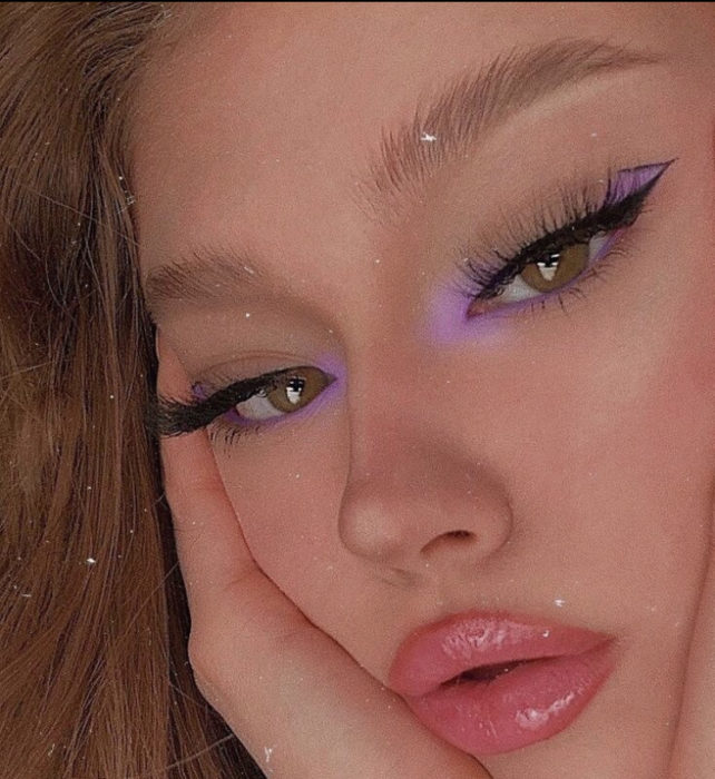 Chica de cabello castaño con delineado negro y morado
