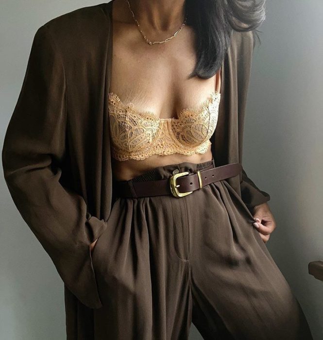 chica morena usando un bustier color beige con traje de vestir café y cinturón negro