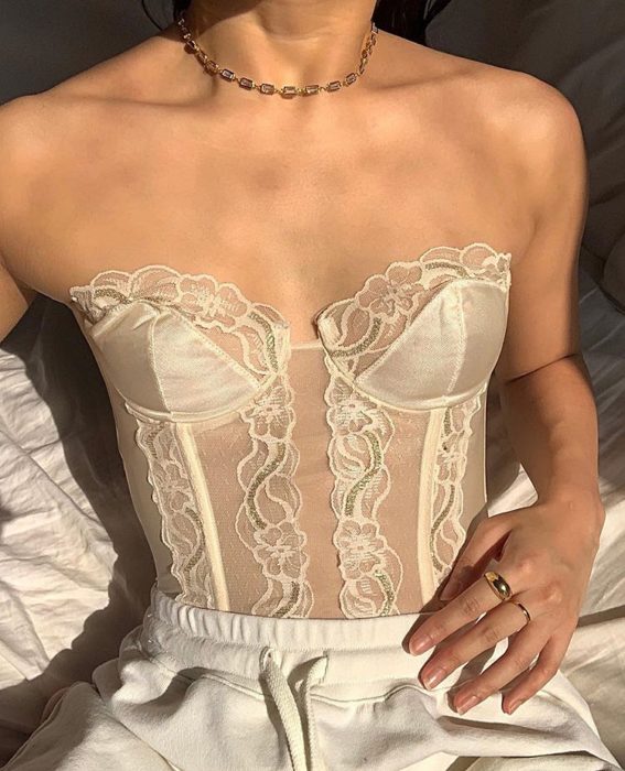 chica con bustier blanco de encaje y pantalón a la cintura blanco