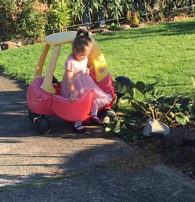 Niña huyendo del jardín al golpear una lámpara con su auto de juguete