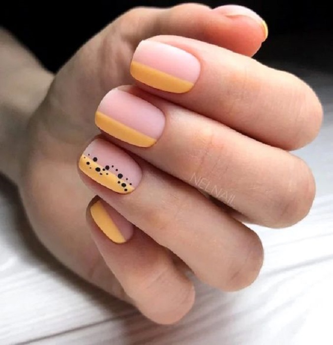 Diseño de manicura en uñas cortas en fondo nude y amarillo con detalles negros