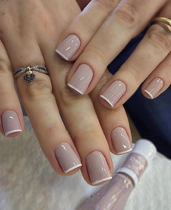 Diseño de manicura en uñas cortas en fondo nude con francés blanco