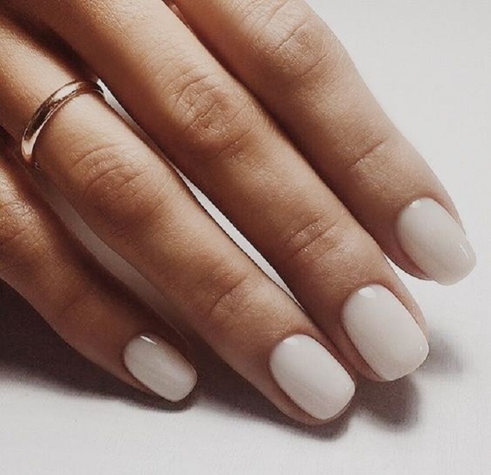 Diseño de manicura en uñas cortas en color blanco perla