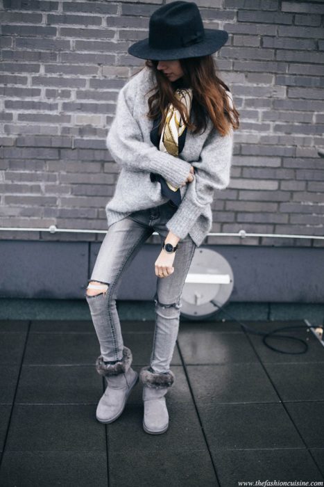 Chica posando con un outfit gris y botas Ugg del mismo tono