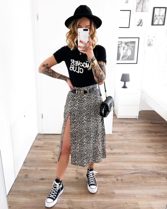 Chica usando una falda midi con estampado animal print con una blusa negra