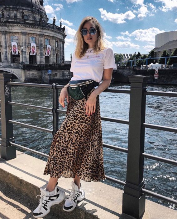 Chica usando una falda midi con estampado animal print con una blusa blanca