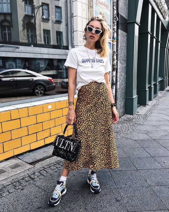 Chica usando una falda midi con estampado animal print con una blusa blanca con estampado