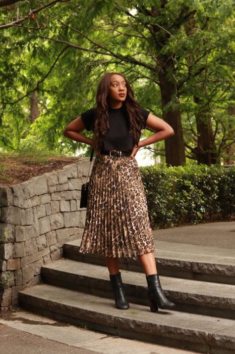 Chica usando una falda midi con estampado animal print con una blusa negra