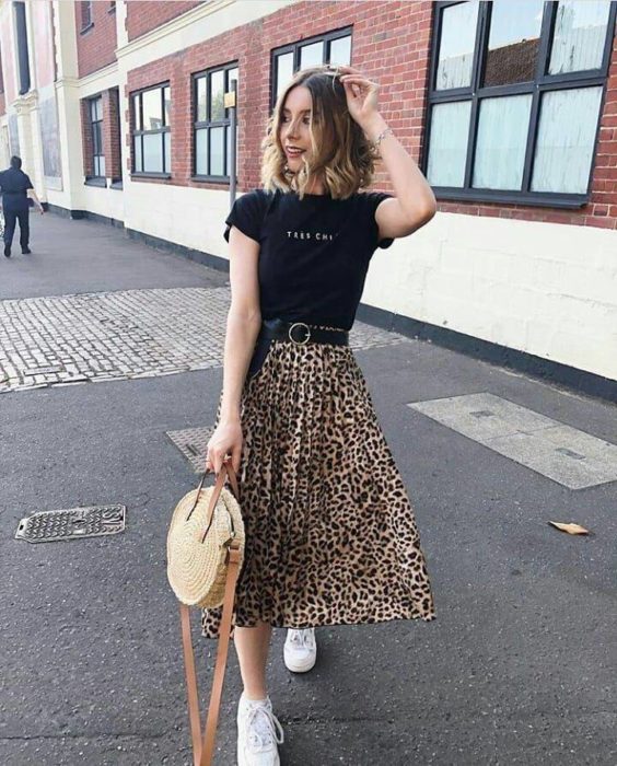 Chica usando una falda midi con estampado animal print con una blusa negra