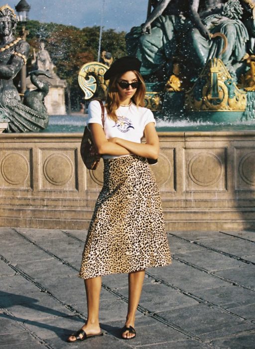 Chica usando una falda midi con estampado animal print con una blusa blanca