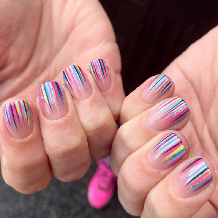 Nail art serpentina en tonos arcoíris con brillo