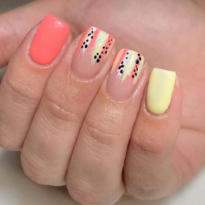 Nail art serpentina en tonos coral y amarillo con detalles negros