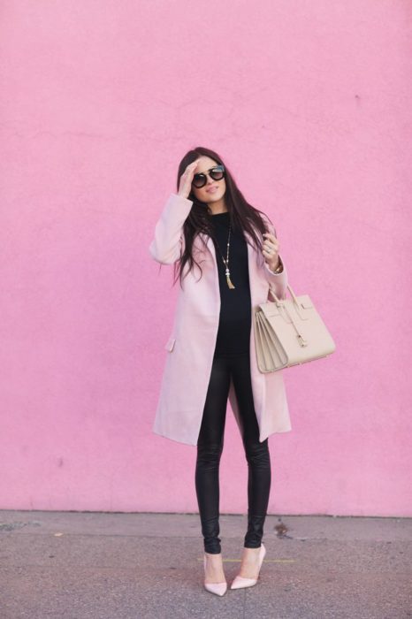 Chica usando outfit con detalles en baby pink en abrigo y blusa y leggins negros