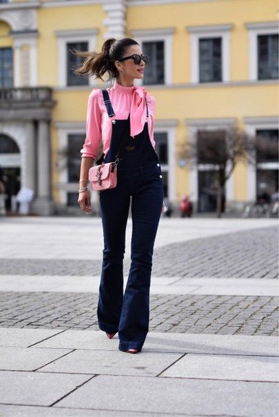 Chica alta y delgada con blusa rosa y overol de mezclilla oscura