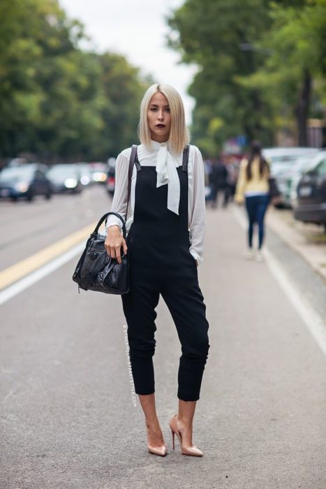 Chica rubia de cabello corto con overol negro y blusa blanca