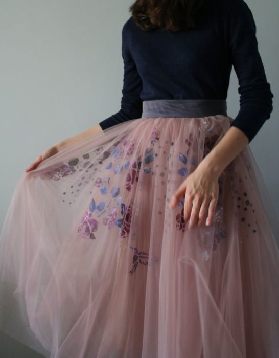 Chica con outfits de falda con transparencias en tono rosa con bordado de flores primaverales