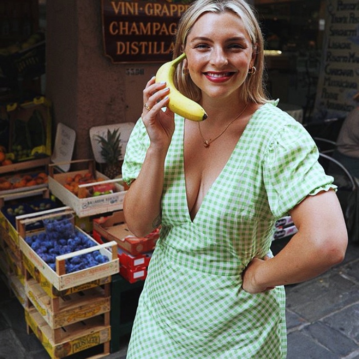 chica rubia con cabello corto usando un vestido verde claro con lunares blancos con escote en v