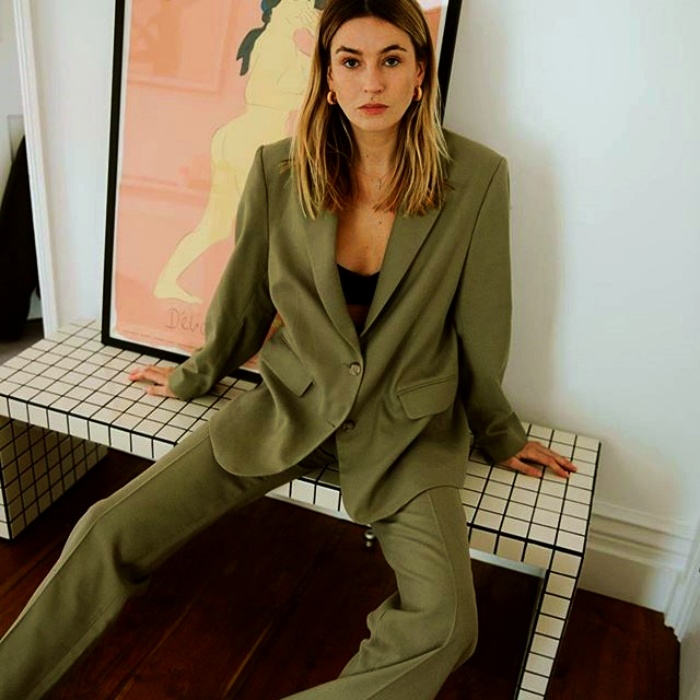chica rubia usando un saco verde olivo y pantalones de vestir verde olivo con top negro debajo