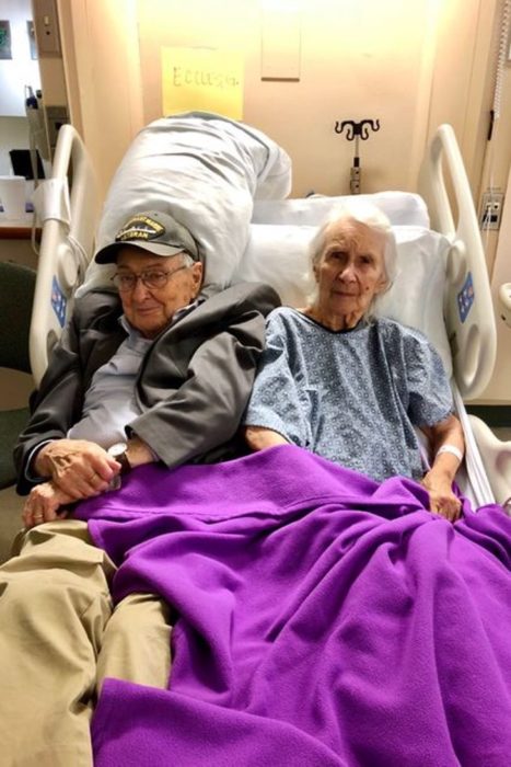 Pareja de abuelitos recostados en una cama dentro de un retiro de ancianos
