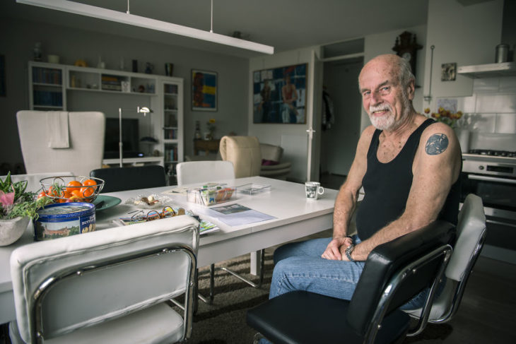Abuelito en su barbería mostrando sus tatuajes