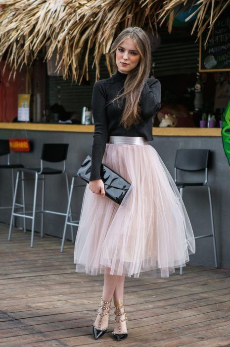 Chica usando falda de tul color rosa bebé y blusa de manga larga color negro