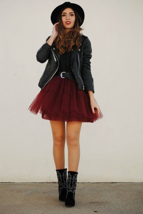 Chica usando falda de tul color guinda con botines, blusa y chamarra de cuero color negros