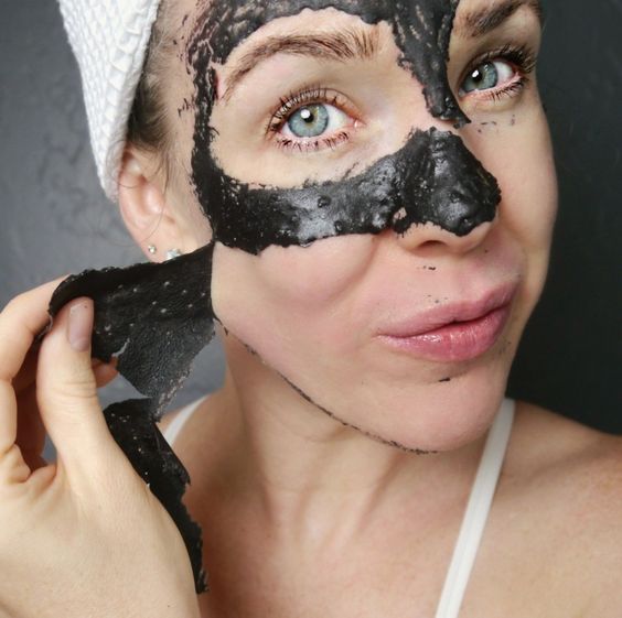 Chica quitando de su rostro una mascarilla de carbón