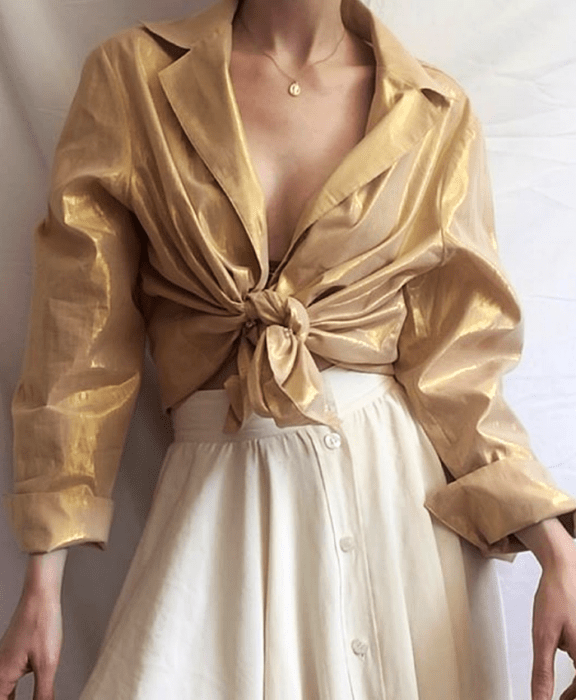 Chica con camisa dorada y falda larga beige