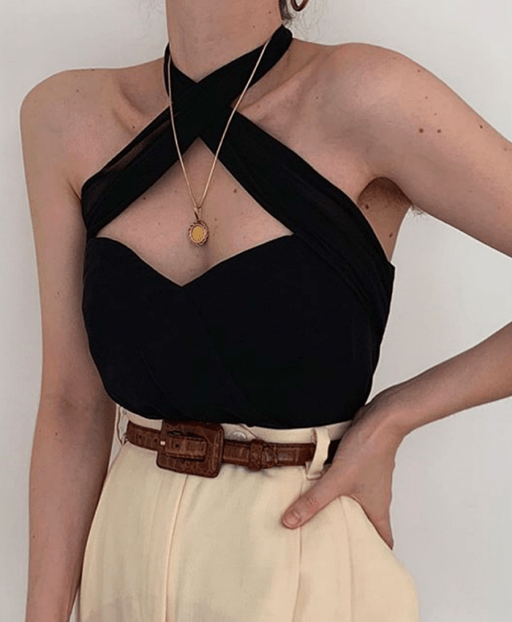Chica con top negro halter y pantalón beige