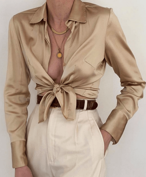 Chica con blusa de botones beige y pantalón blanco