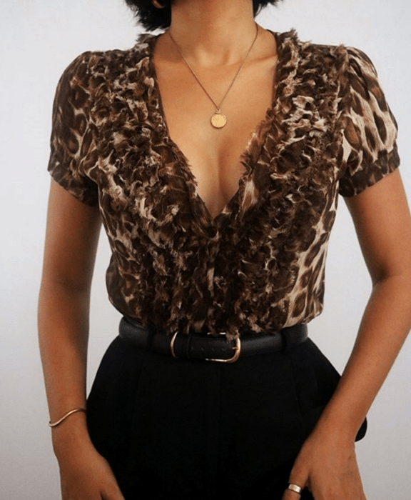 Chica con blusa de animal print y pantalones negros