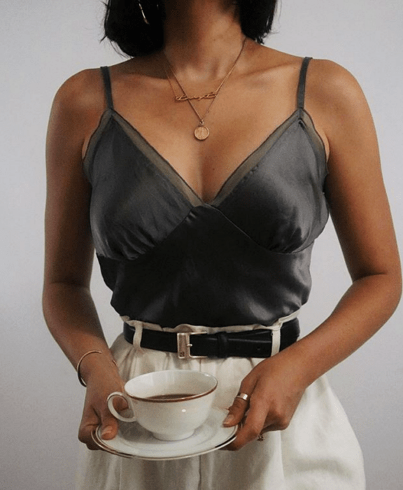 Chica con top de tirantes gris y pantalones blancos