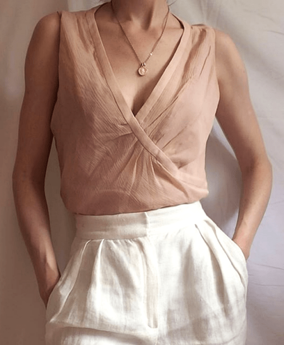 Chica con top rosa pálido y pantalón blanco