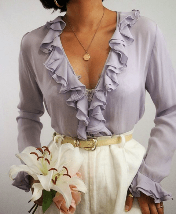 Chica con blusa lila de manga larga y cinturón beige