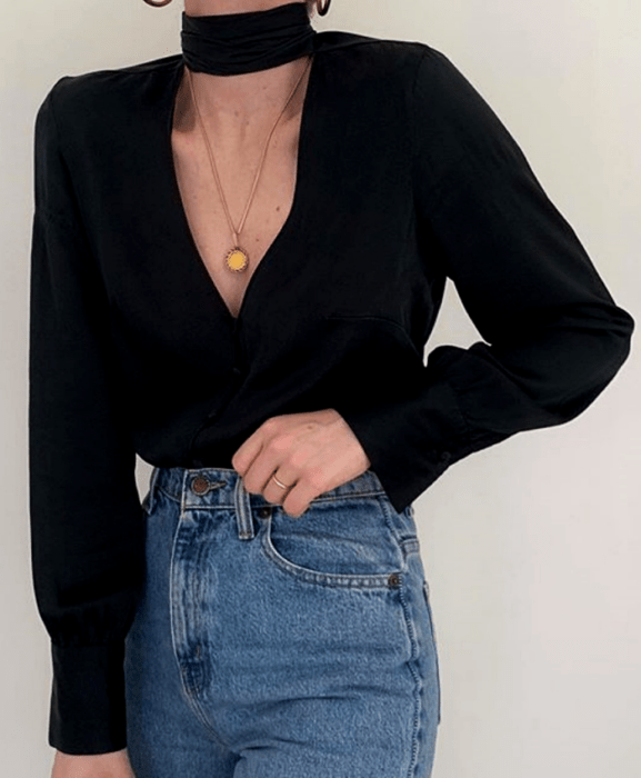 Chica con blusa negra con cuello alto y jeans a la cintura