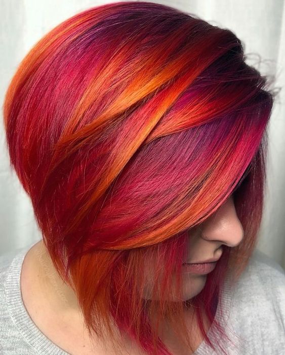 Chica con melena color rosa con naranja y rojo