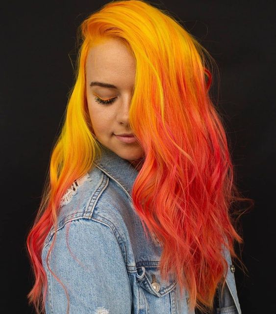 Chica con cabello largo color amarillo en el crecimiento y rojo en las puntas