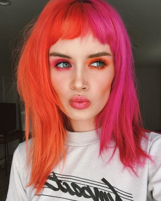 Chica con melena media mitad naranja fuego, mitad rosa